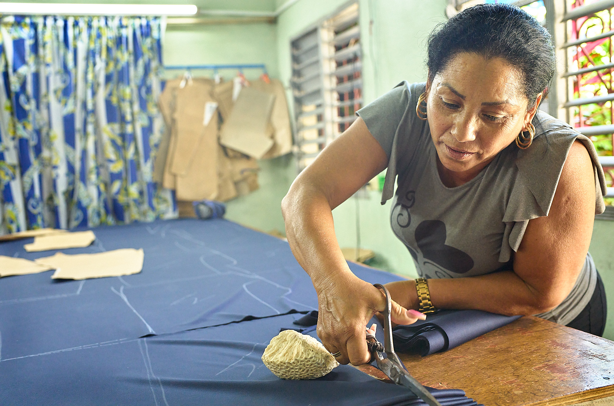 Naomi draws the blade through layers of deep blue fabric that will become school uniforms. In a workshop once run by the Cuban state, she took over as owner—and tripled her workers’ salaries in the process. One of the few with the skill to cut patterns by hand, Naomi represents a quiet but real shift in Cuba’s economy: the rise of pymes, or private businesses. In a country full of economic struggle, this place felt different—productive, dignified, and working.