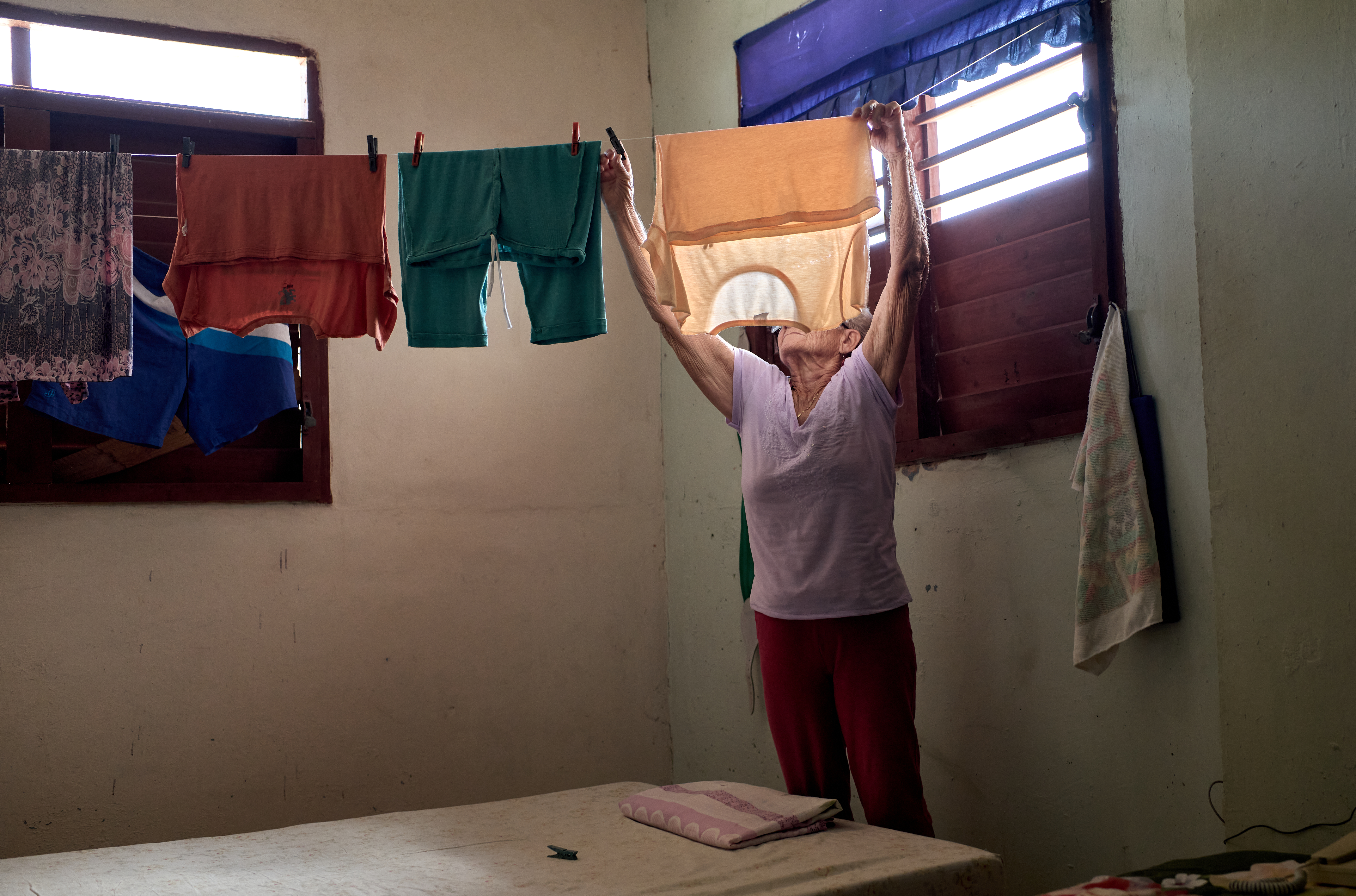 Improvised Clothesline in the Bed Room:    Laundry is hung with makeshift clothesline strung through her Havana bedroom. With no outdoor space or dryer, rooms double as a drying rack.