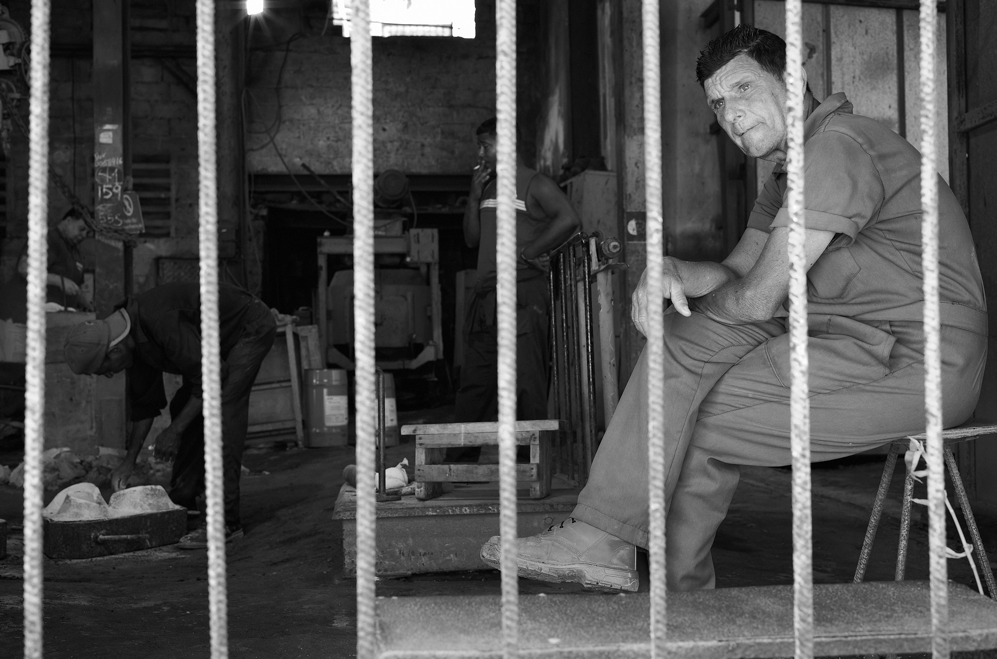 We were told the boss was on his way, and the mood shifted. My fixer and I quietly made a plan: run in opposite directions if it went bad. The men kept working, but our cameras paused. In Cuba, photographing a government-run facility can lead to persecution. But when the boss arrived, he didn’t yell or stop us. He just sat down with us, outside the bars — and started talking about his sick child.