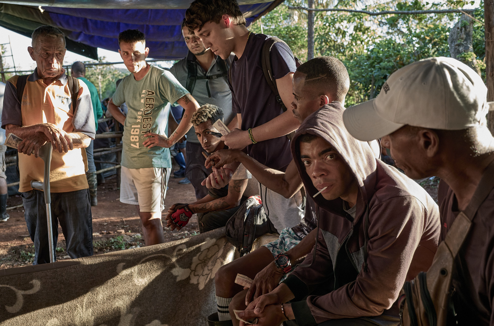 A participant in the dice game looks up, noticing my camera. He didn’t stop me—just observed. His quiet acceptance signaled I was, at least for now, allowed to witness.