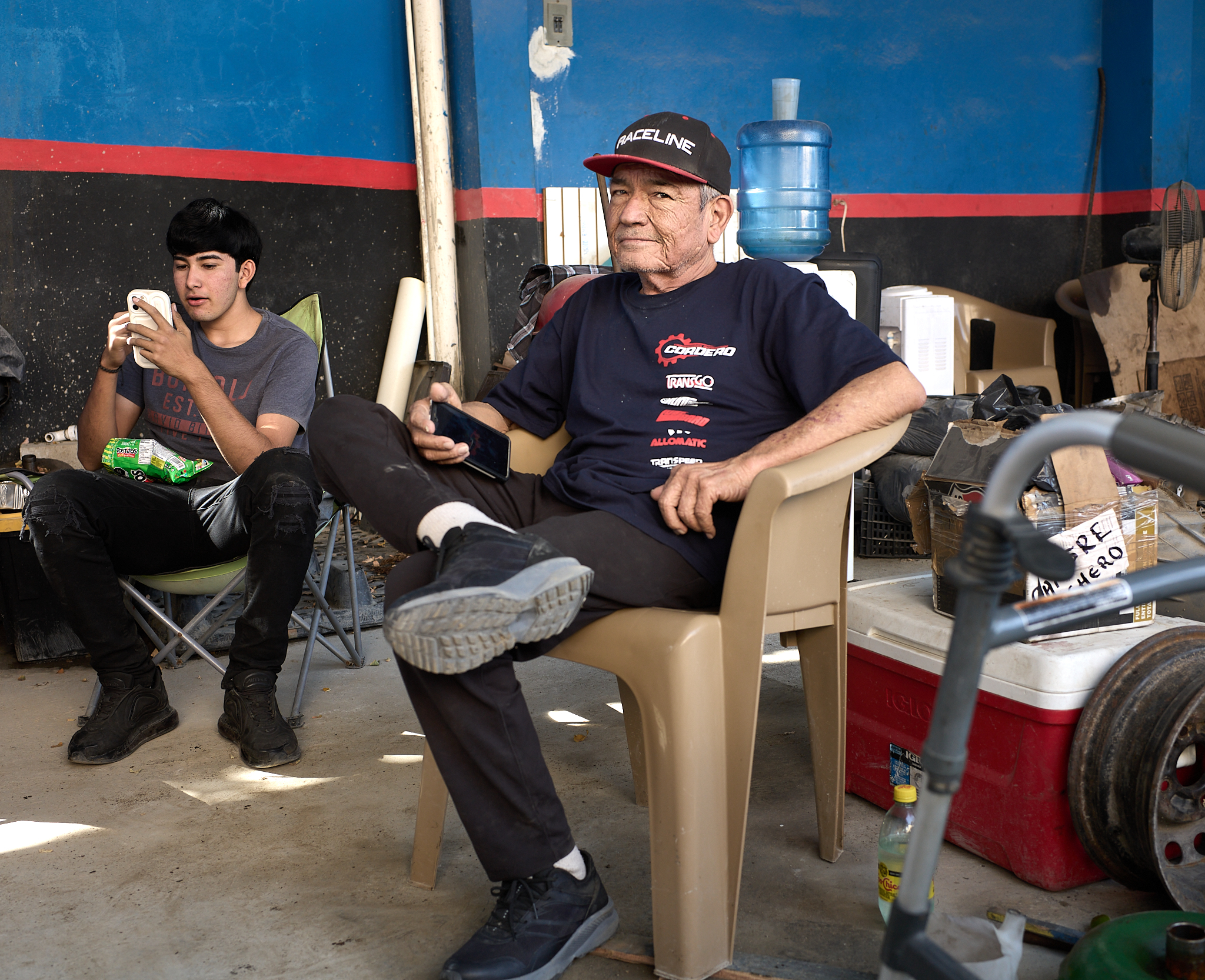 A family rests inside their auto repair shop in Cabo San Lucas, pausing between customers during the workday.