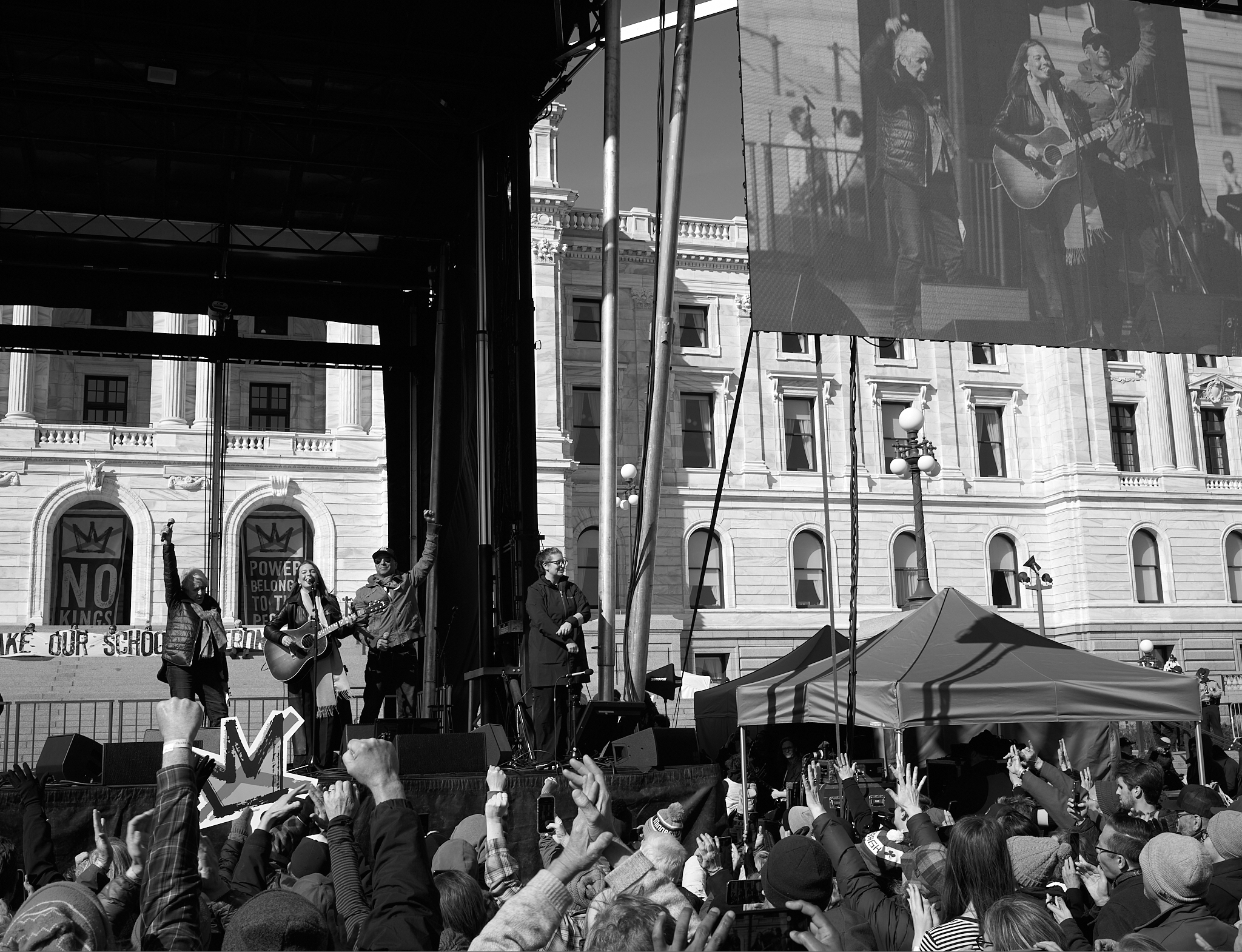 Joan Baez and Maggie Rogers perform during the “No Kings” rally at the Minnesota State Capitol in Saint Paul, Minnesota on March 28, 2026, as a third individual joins them on stage. 