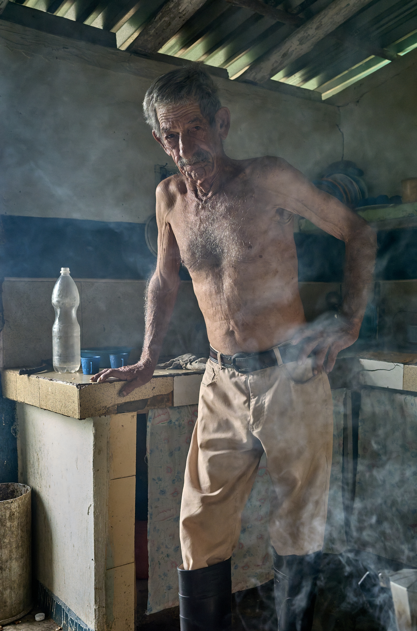 In the smoke-filled back kitchen, Miguel prepares coffee and breakfast at dawn. He began running this farm at just nine years old after his father died—part of five generations who have worked this land in Viñales.