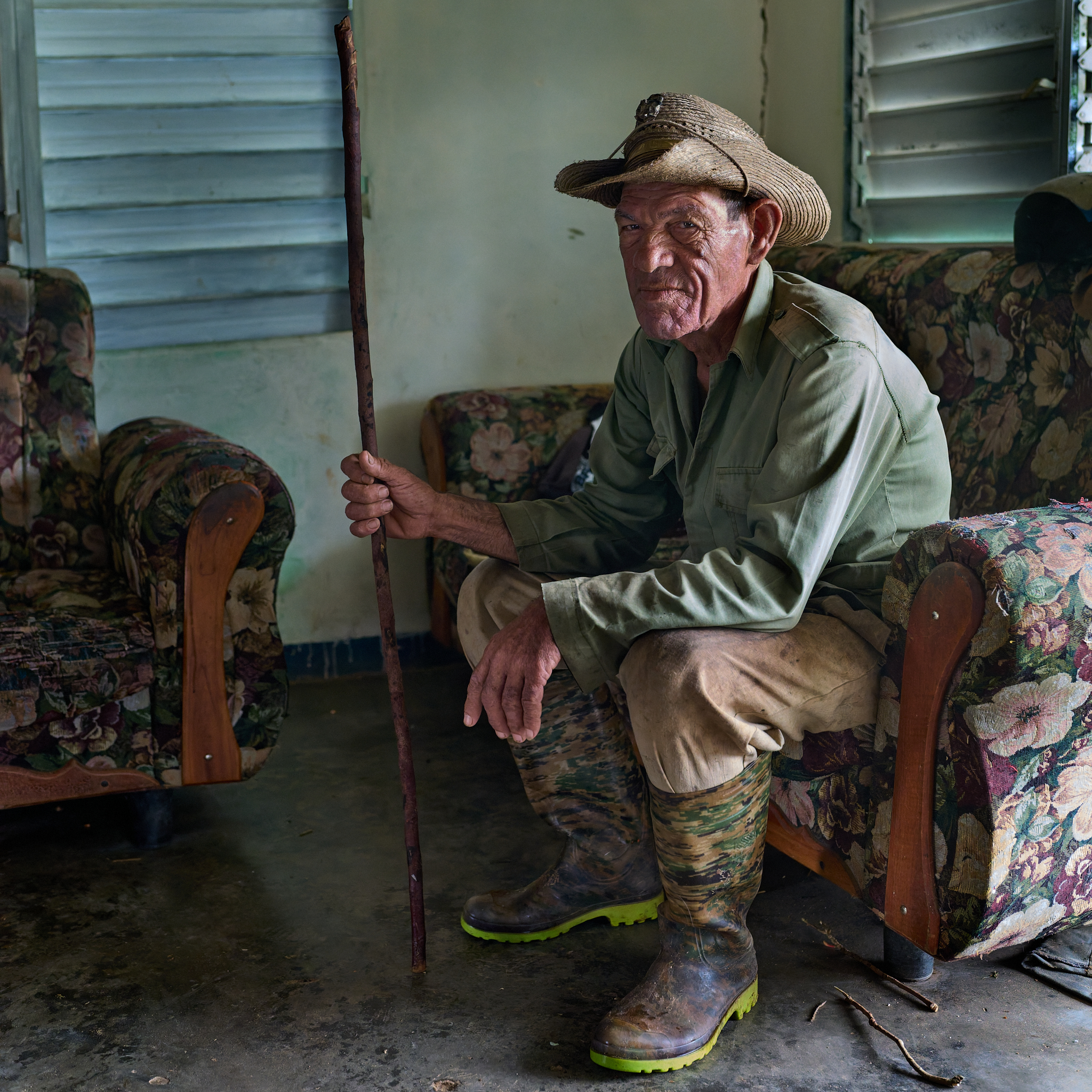 A neighboring farmer rests inside Michel’s home—one of many informal gathering places in Viñales where news, like the nearby cockfight he mentioned, circulates the old way: in person, over coffee, and face to face.