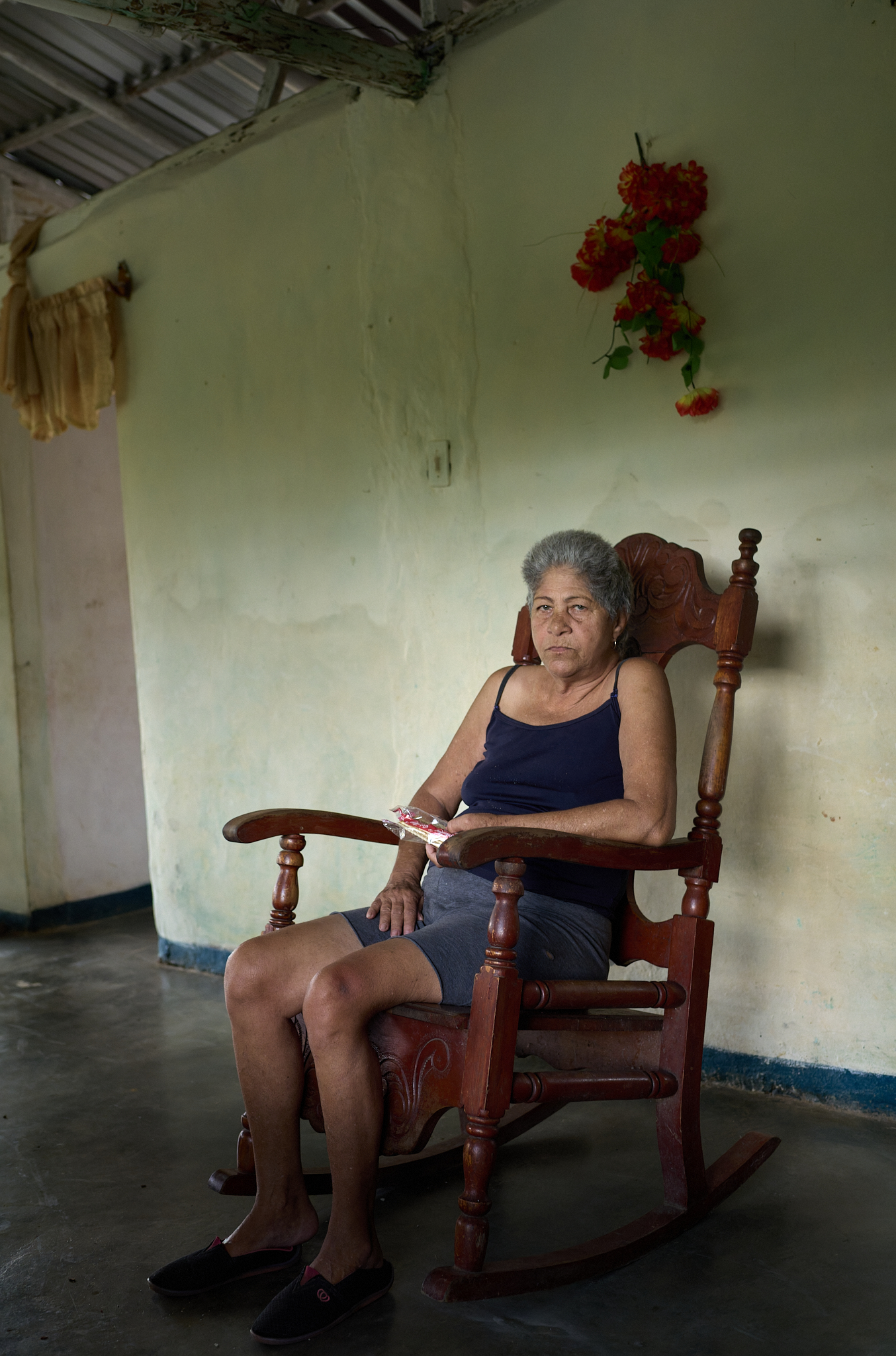 A local woman who helps care for Michel’s household takes a short rest in the living room. Like much of the home, this space is simple and open—rooms are divided by 6-7 foot walls, with curtains instead of doors, and a bathroom tucked behind the hallway wall.